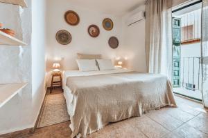 Canillas de AceitunoEncanto Guesthouse的白色的卧室设有床和大窗户