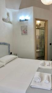 马达莱纳La Casa di Dario的卧室配有白色床和毛巾