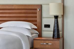 美因河畔法兰克福法兰克福朱美拉酒店的一间卧室配有一张床,床头柜上配有一盏灯