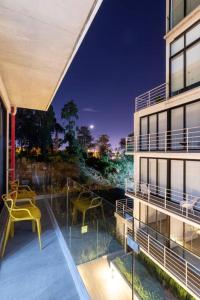 危地马拉Encanto Cayala, Apartamento moderno a minutos caminando de Embajada USA y Paseo Cayala的阳台,建筑中配有黄色的桌子和椅子