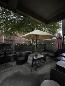 布鲁克林Brooklyn Luxury Spring Retreat with Private Outdoor Space的庭院配有桌子、遮阳伞和椅子