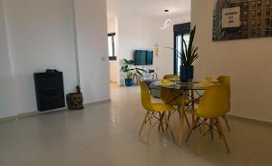 阿卡A modern apartment in Acre的一间带桌子和黄色椅子的用餐室