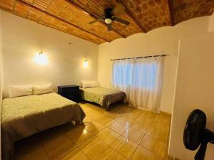 洛德马科斯Casa San Marcos的一间卧室配有两张床和吊扇