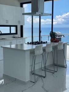 拉斯特拉纳斯Villa Ocean Blue的厨房配有白色的柜台和白色的柜台凳子