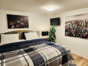 蒙克顿Private Basement Suite in Central Moncton的卧室配有一张床,墙上挂有两幅画