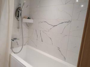 塔林Bright 3-room apartment in Mustamäe的白色的浴室设有浴缸和大理石墙。