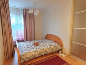 塔林Bright 3-room apartment in Mustamäe的卧室里设有一张床,上面有一只动物