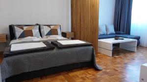 VoždivacBMM LUX APARTMENT的一间卧室配有一张床和一张蓝色的沙发
