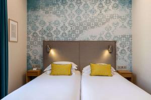 斯特拉斯堡大都会贝斯特韦斯特优质酒店酒店的一间卧室配有两张带黄色枕头的床