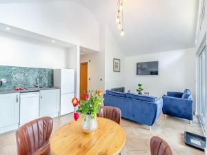 科尔福德Greenacres Cabin的厨房以及带桌子和蓝色椅子的客厅。