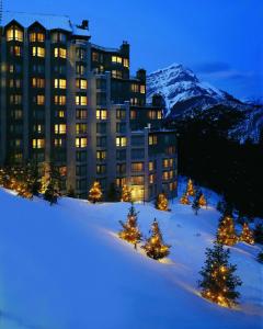 班夫The Rimrock Resort Hotel Banff的一座大建筑,位于一座白雪覆盖的山顶上
