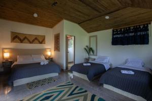 米卡Colores de la Sierra的一间卧室设有两张床和木制天花板