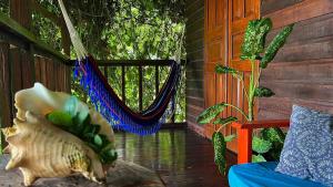 巴斯蒂门多斯True Nature Jungle House的一个带吊床和窗户的门廊