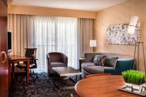 肖尼堪萨斯城肖尼万怡酒店的酒店客房设有一间带沙发和椅子的客厅