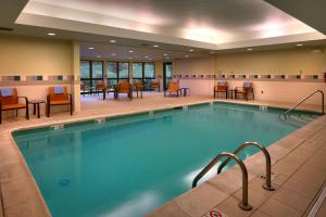 肖尼堪萨斯城肖尼万怡酒店的游泳池位于酒店客房内,配有桌椅