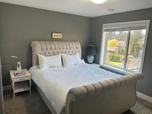 维多利亚Galloping Goose B&B in Beautiful Victoria的一间卧室设有一张大床和一个窗户。