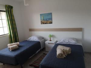阿尔热祖尔Casa Manuel J. J. M -Alfambras, Aljezur - Quiet Country House的配有蓝色床单的客房内的两张床