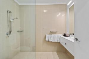 赫维湾海湾旁的伊甸园酒店的带淋浴和玻璃淋浴间的浴室