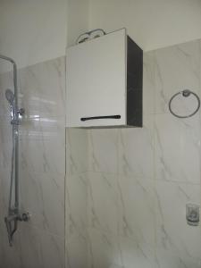 阿克拉KESEWAA's APARTMENT的带淋浴的浴室和白色橱柜。