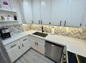 棕榈泉MCM Condo Downtown Palm Springs的厨房配有白色橱柜和水槽