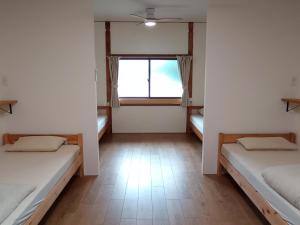 InokuchiGuesthouse tonari的客房设有两张床和窗户。