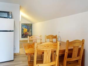 王室港Holiday home KUNGSHAMN XVII的厨房配有木桌、椅子和冰箱。