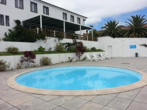 Rosário-Lagoa星之圣母旅游公寓的一座大蓝色游泳池,位于房子前