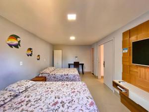 瓜拉派瑞Apt FRENTE MAR MEAIPE COMPLETO的酒店客房设有两张床和一台平面电视。