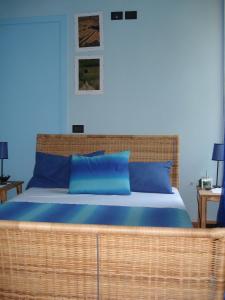 阿尔巴罗坎达德尔巴巴列斯科酒店的一间卧室配有带蓝色枕头的大柳条床