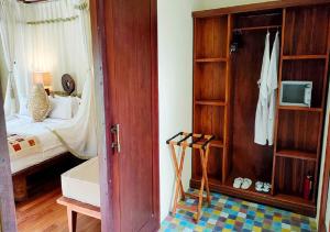 乌布尼瓦纳别墅酒店的客房设有带一张床的卧室和衣柜。