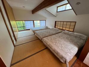 Muraokakakayama hutte的带2扇窗户的客房内的2张床