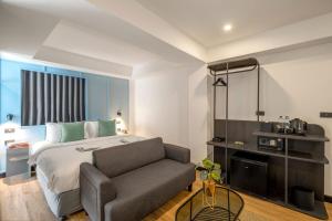 曼谷Myhotel Cmyk@Ratchada的酒店客房,配有床和沙发