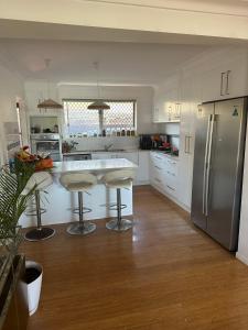 黄金海岸Room in a Family home的厨房配有白色橱柜和不锈钢冰箱