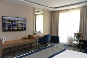 金沙Admiral Hotel - Ultra All Inclusive & Private Beach的酒店客房配有书桌和床。