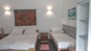 班塔延岛Orchidia House Santa Fe Bantayan Island的小房间设有两张床和一张桌子
