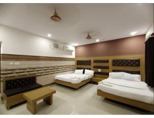 坎普尔Chhabra Guest House, Kanpur的一间设有两张床的房间,内设一张长凳