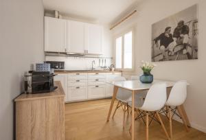 威尼斯Santa Croce Design Apartment R&R的厨房配有白色橱柜和桌椅