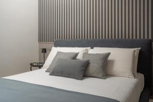 威尼斯Santa Croce Design Apartment R&R的床上铺有白色和灰色的枕头