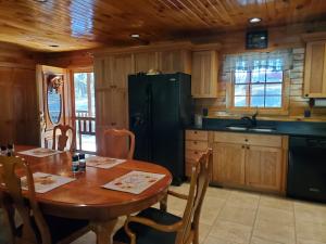MillerstownSnyder's Knob的厨房配有桌子和黑冰箱。