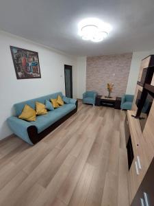 普洛耶什蒂Eugenia Apartament的客厅配有蓝色的沙发和黄色的枕头。