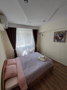 普洛耶什蒂Eugenia Apartament的一间卧室设有一张大床和一个窗户。