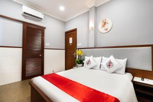 胡志明市Văn Hoa Hotel的卧室配有一张大白色床和红色毯子