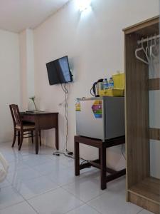 Phanat NikhomV at Panus的客厅配有桌子、电视和冰箱。