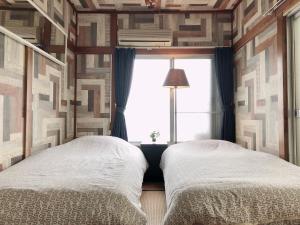 东京羽田机场旅馆的带窗户的客房内设有两张单人床。