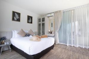 卡马拉海滩Oceana Phuket的卧室设有一张白色大床和一扇窗户。