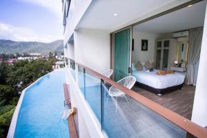 卡马拉海滩Oceana Phuket的酒店客房带一间卧室和一个游泳池