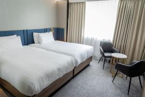 科尔切斯特Marks Tey Hotel Colchester的配有一张床和一把椅子的酒店客房