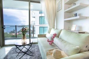 卡马拉海滩Oceana Phuket A51的客厅设有一张沙发、一张桌子和一个大窗户