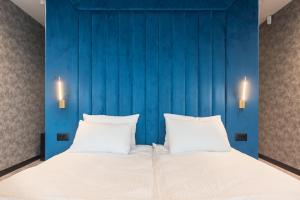 瓦尔纳Lotus Luxury Rooms的一间卧室设有蓝色的墙壁和一张带两个枕头的床