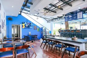 暹粒The Big Easy Siem Reap的餐厅拥有蓝色的墙壁和木制桌椅